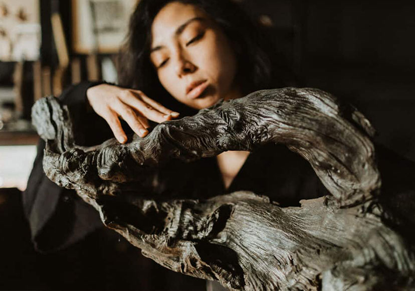 Woman with large piece of bog oak at Celtic Roots Studio.
